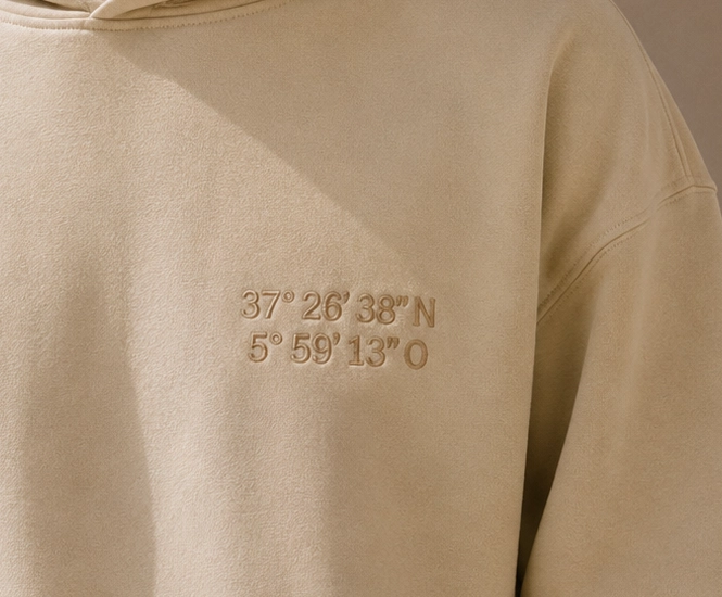 Sudadera con coordenadas bordadas en el pecho.