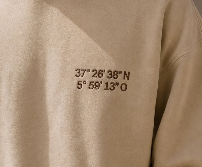 Sudadera con coordenadas bordadas en el pecho.